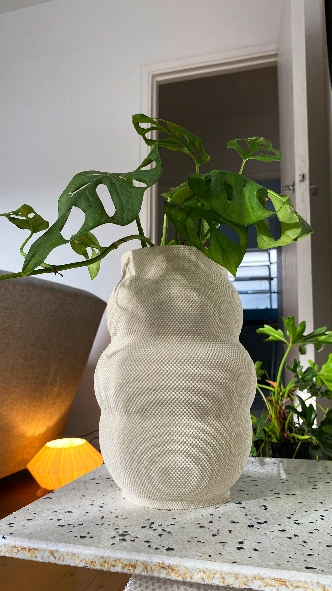 Vase organique blanc texturé avec monstera imprimé en 3D